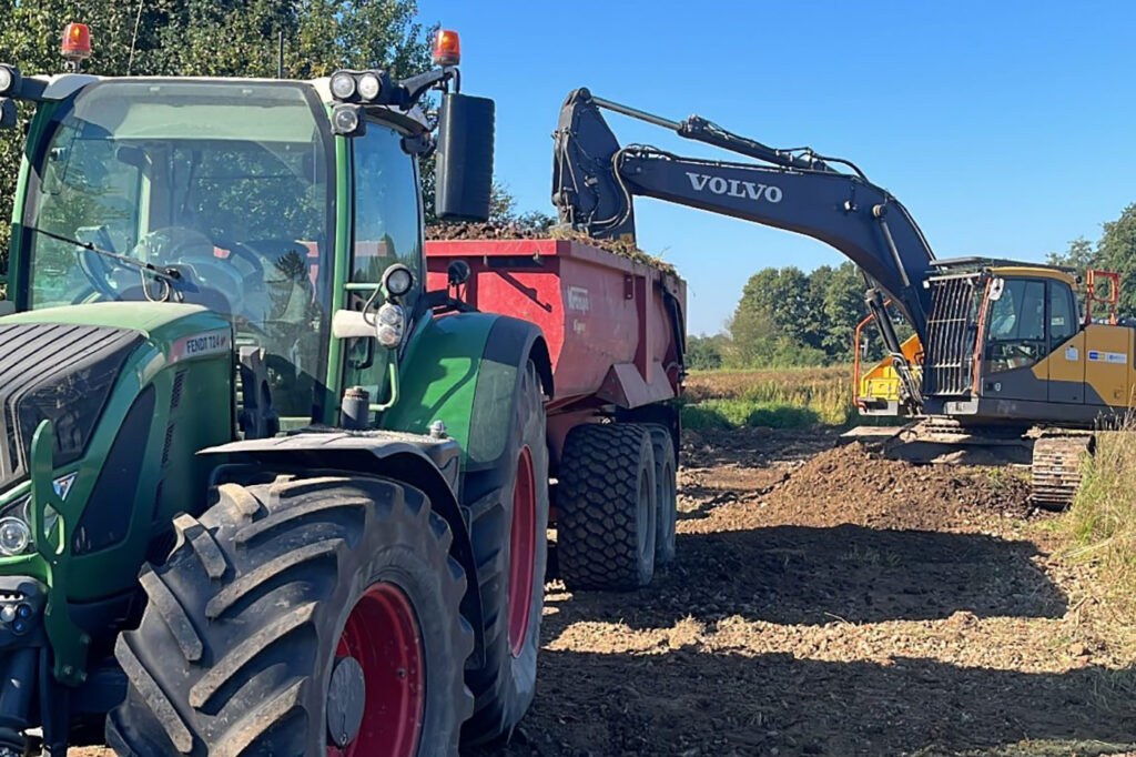 Bagger mit Traktor und Mulde Bagger mit Traktor und Mulde